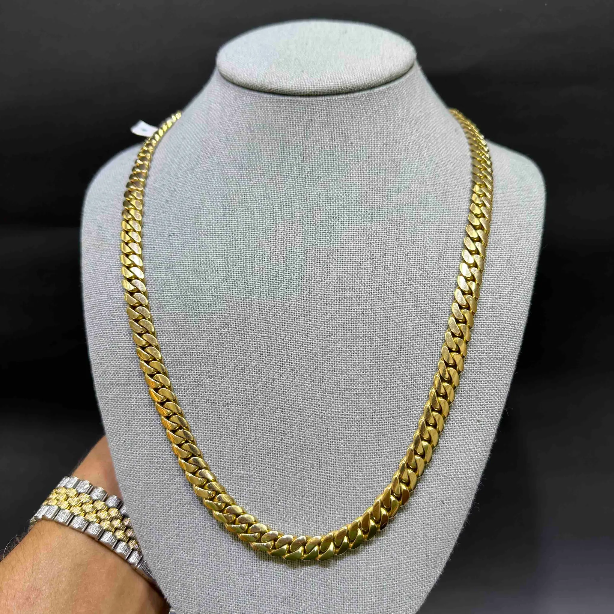 Gold Cuban link chain on a display bust.