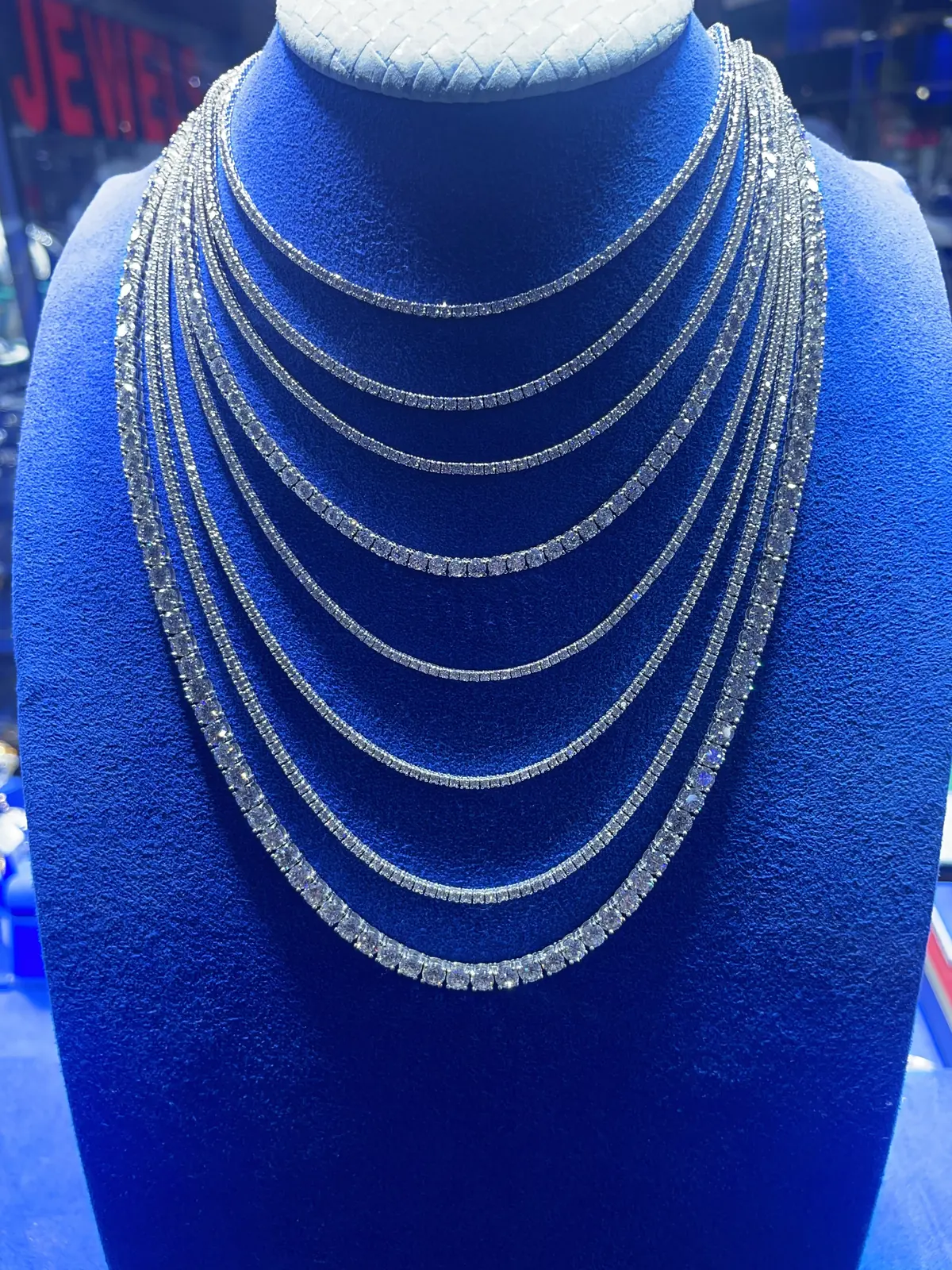 Diamond tennis necklaces layered on a display bust at Roma Jewelry.