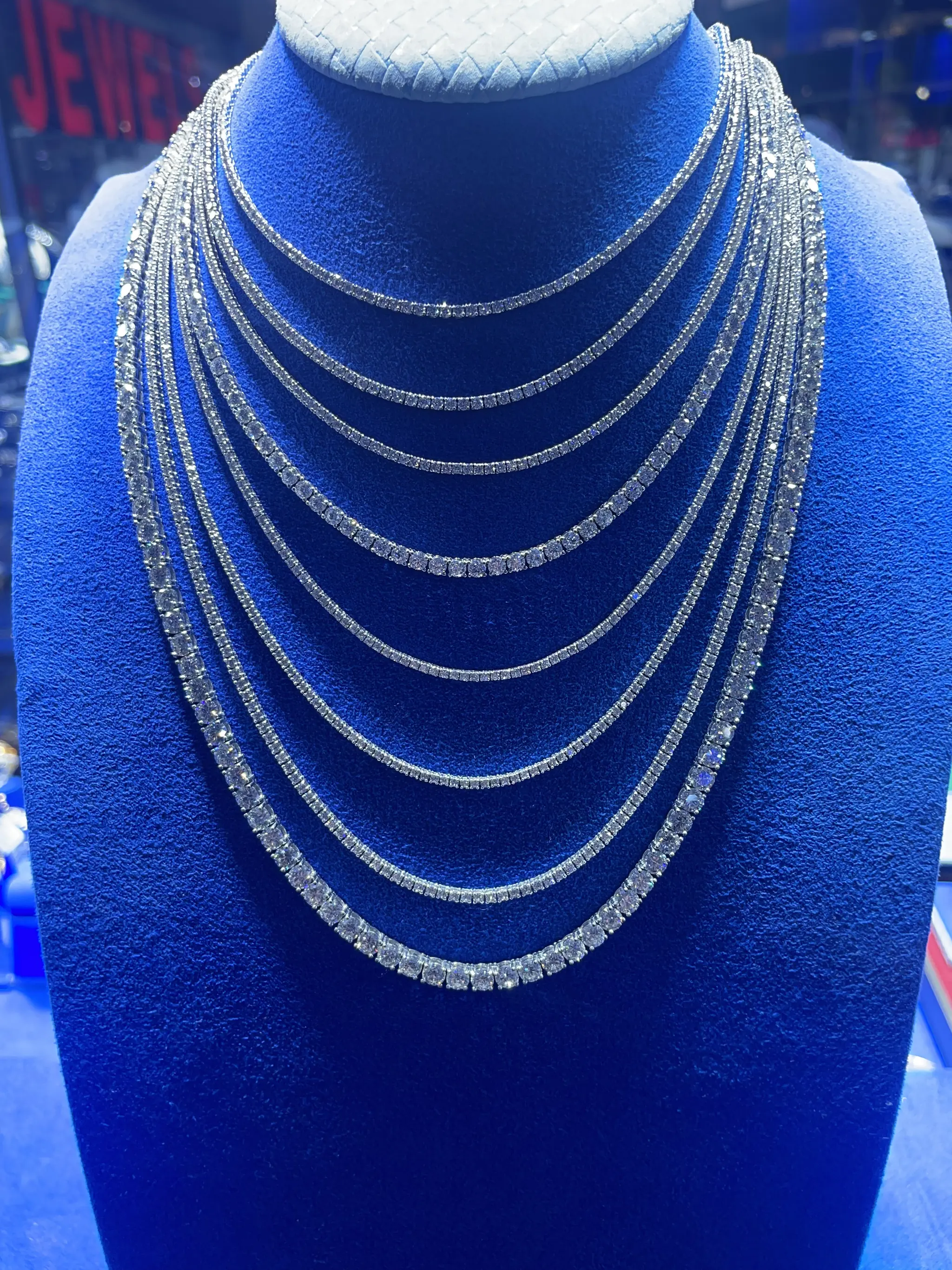 Diamond tennis necklaces layered on a display bust at Roma Jewelry.