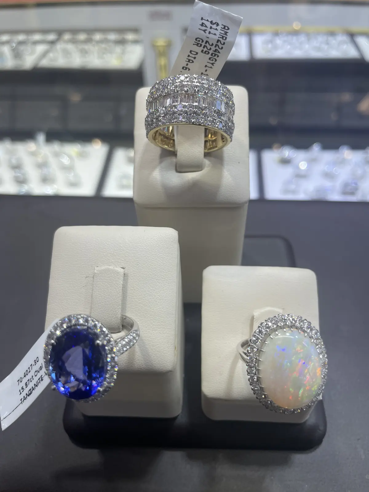 Sapphire, opal and diamond rings on display stands at Roma Jewelry.