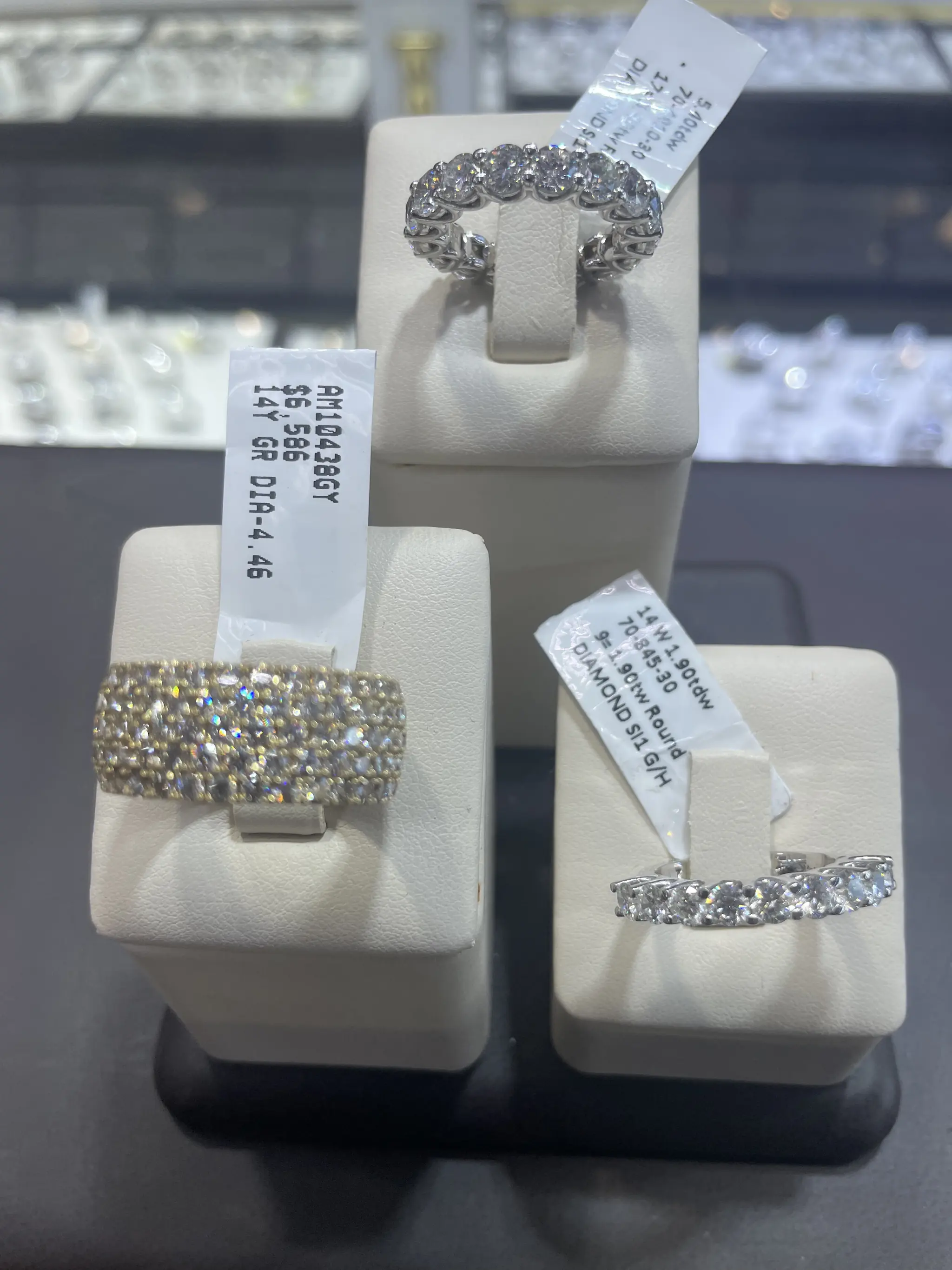 Diamond eternity bands and wedding rings on display stands at Roma Jewelry.
