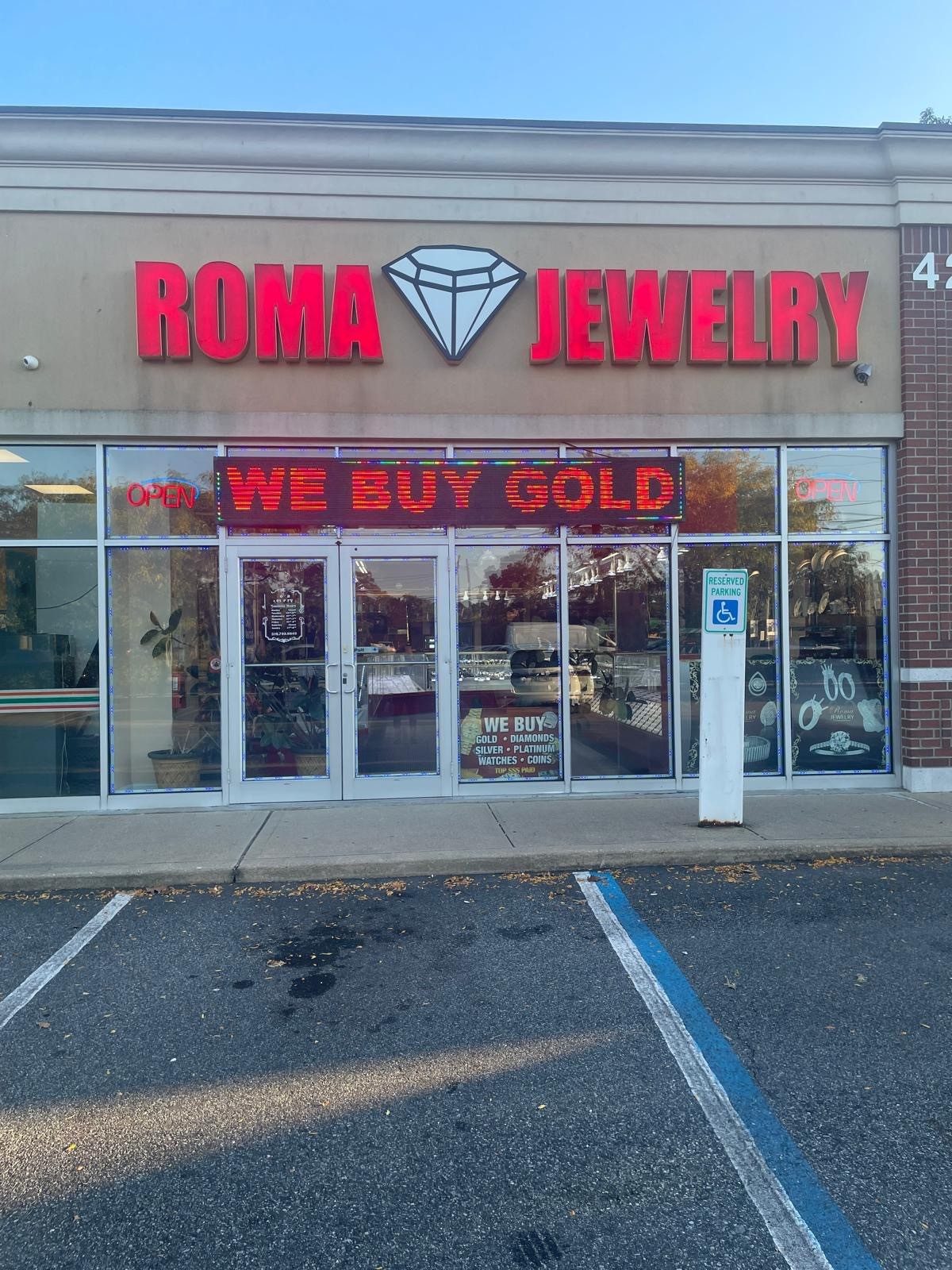 Roma Jewelry storefront on Sunrise Highway in Massapequa, with the red Roma Jewelry sign and a We Buy Gold display above the door.